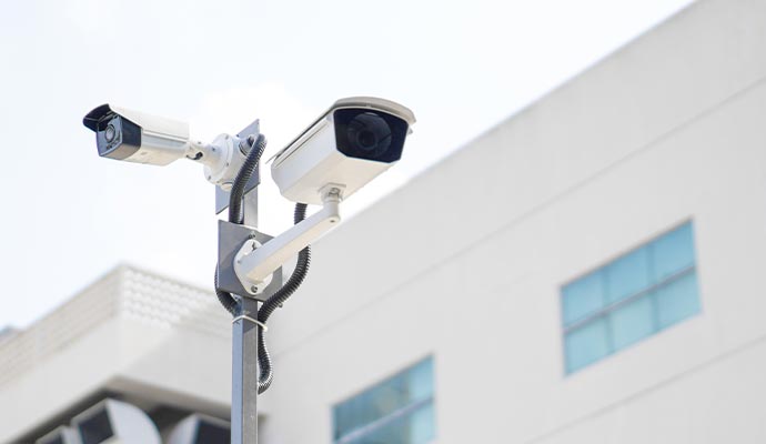 a couple of security cameras installed on a pole