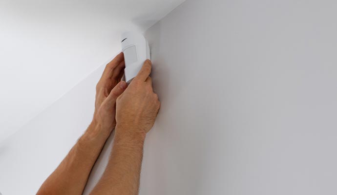 a person installing motion sensor 