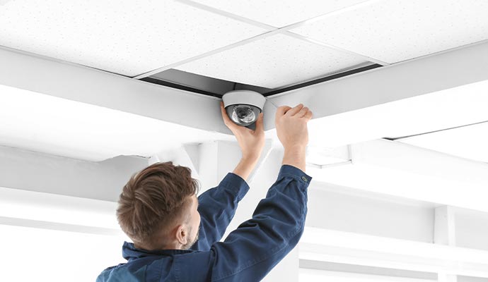 person installing a dome security camera