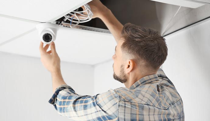 A person installing a CCTV camera