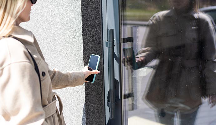 person using smartphone for touchless door system access