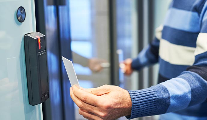 A person using an access card to unlock a door.